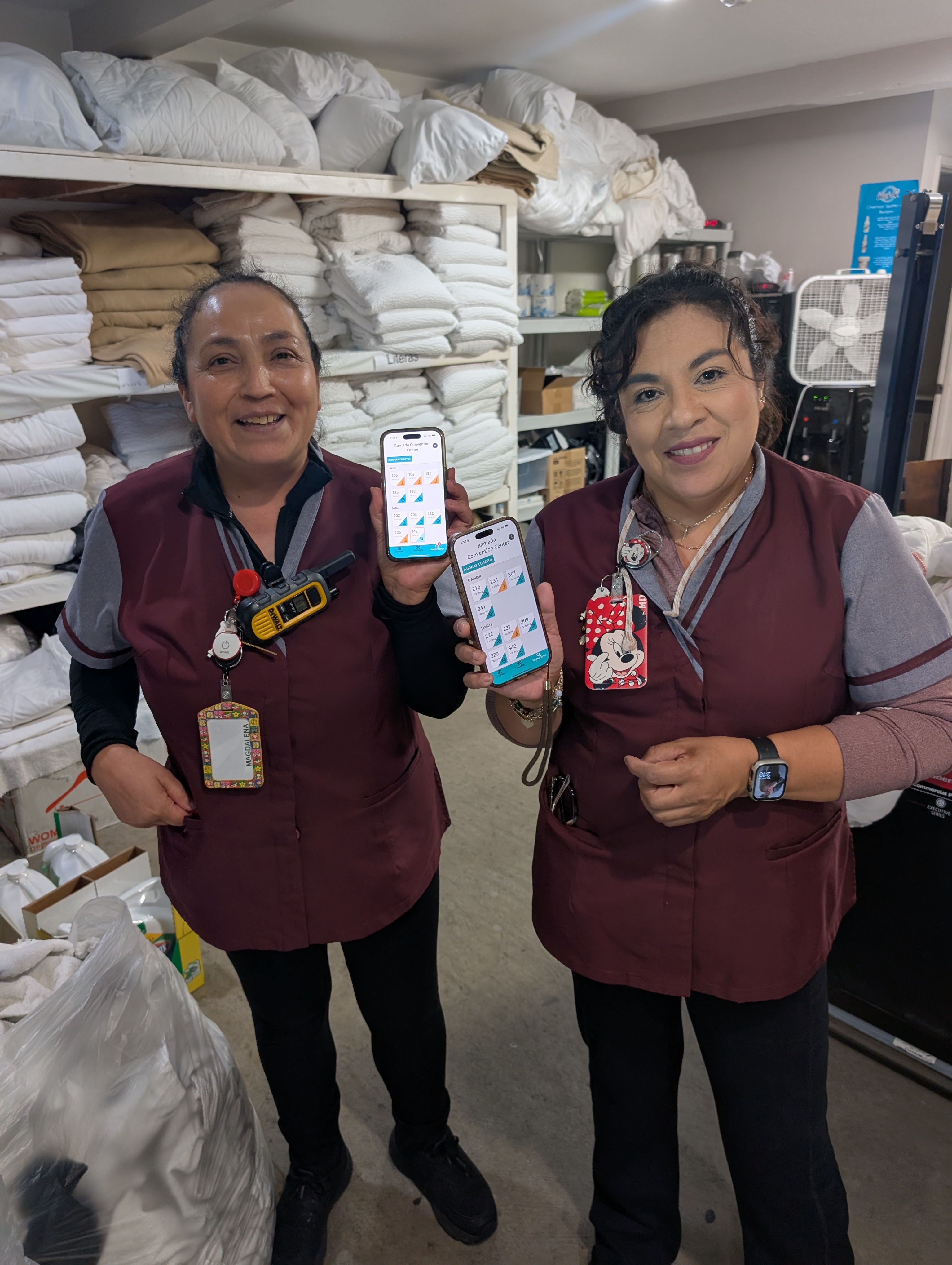 Two housekeepers holding phones with their Lodgebook room assignments